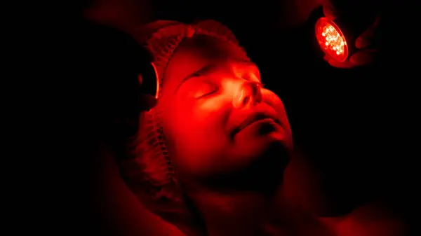 Kozmetik uzmanı yüz gençleştirme için LED ışık terapisi uyguluyor.. 