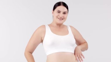 Stüdyoda açık gri arka planda poz veren güzel, gülümseyen kıvrımlı kadın. güzellik, sağlık, vücut bakımı, kozmetoloji, cilt bakımı kavramı