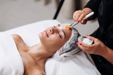 Gencecik, rahat bir kadının dış görünüş portresi cilt geliştirme prosedürü üzerine. Nemlendirici için özel maske ve krem kavramı. Kişisel bakım spa konsepti. Kozmetik bilimi reklamı, temizlik