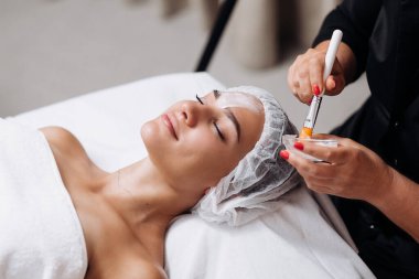 Gencecik, rahat bir kadının dış görünüş portresi cilt geliştirme prosedürü üzerine. Nemlendirici için özel maske ve krem kavramı. Kişisel bakım spa konsepti. Kozmetik bilimi reklamı, temizlik