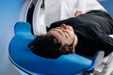 Modern hastanedeki MR makinesindeki genç adam.               