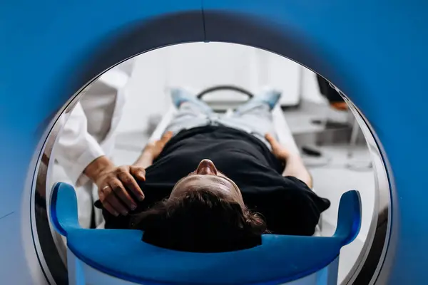 Modern hastanedeki MR makinesindeki genç adam.               