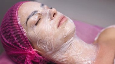 Kaplıca salonunda yüz maskesi takan güzel genç bir kadının yakın çekimi.. 