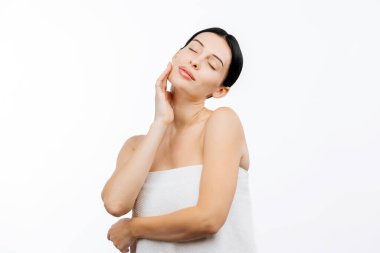 Beyaz arka planda poz veren kusursuz cilde sahip güzel genç bir kadının portresi.           