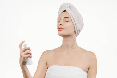 Kozmetik ürünlerle uğraşan genç bir kadının portresi. Vücudunda ve saç bakımında hidratasyon ve parlaklığın önemini vurgulayarak özgüven yayıyor..