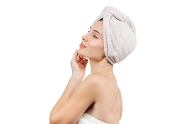 Kafasında havluyla tenine dokunan güzel genç bir kadın beyaz arka planda izole edilmiş.    