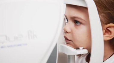 Pediatrik bir göz doktoru küçük bir kızın gözlerini inceliyor. Oftalmik enstrüman. Dikkatli tanı ve çocukların göz sağlığı için bakım.