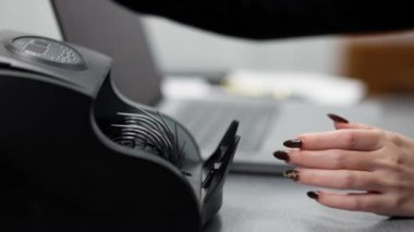 Bir borsacı, dizüstü bilgisayarın önündeki bir hesap makinesinde elinde çizelgeyle dolarları sayar. Dolar, kripto para birimlerini alıp satarak kazanıldı. Finans, bankacılık ve kripto para kavramı.