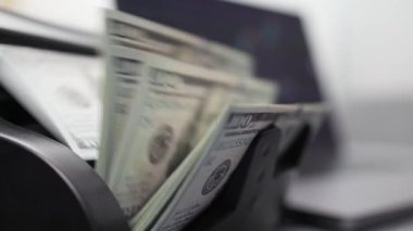 Bir borsacı, dizüstü bilgisayarın önündeki bir hesap makinesinde elinde çizelgeyle dolarları sayar. Dolar, kripto para birimlerini alıp satarak kazanıldı. Finans, bankacılık ve kripto para kavramı.