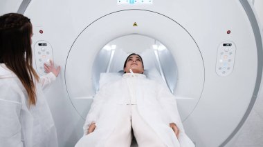 Genç bayan doktor hastayı MRI taraması için hastanede hazırlıyor.