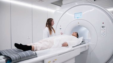 Genç bayan doktor hastayı MRI taraması için hastanede hazırlıyor.