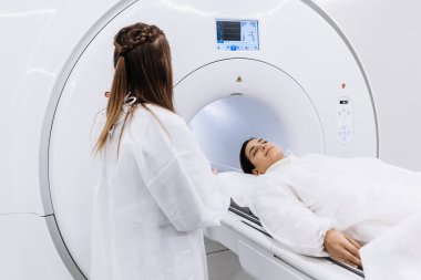 Genç bayan doktor hastayı MRI taraması için hastanede hazırlıyor.