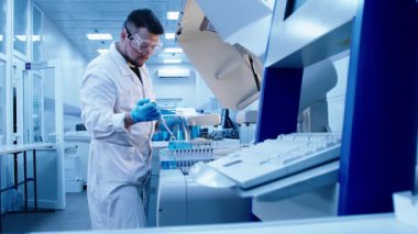 Modern laboratuara sıvı ve pipetle gelişmiş ekipmanlarla birlikte test tüplerini yakın çekim yapın. Yüksek teknolojili bir laboratuarda araştırma ve deneyler kavramı..