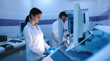 Bilim adamları modern ekipmanlarla bir laboratuarda çalışıyorlar. Modern bir laboratuvarda özel makineler kullanarak örnekleri ve genetik materyalleri analiz eder. Bilimsel araştırma kavramı.