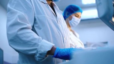 Bilim adamları modern ekipmanlarla bir laboratuarda çalışıyorlar. Modern bir laboratuvarda özel makineler kullanarak örnekleri ve genetik materyalleri analiz eder. Bilimsel araştırma kavramı.