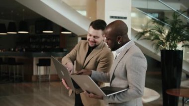 İki iş adamı, bir Afrikalı Amerikalı ve bir Avrupalı modern bir ofis binasının koridorundaki konferanstan önce bir projeyi tartışıyorlar. Mesleki atmosfer, işbirliği ve teknolojiyi kavra.