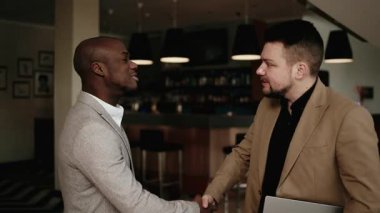 İki iş adamı başarılı bir anlaşmadan ya da konferanstan sonra koridorda yürür ve konuşurlar. Başarılı ortaklıkları, profesyonelliği ve ticarete olan güveni kavrayın.