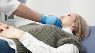 Kadın endokrinolog ultrason ofisinde kadın bir hastaya ultrasonografi yapıyor. Tiroit bezinin ultrason kontrolleri..