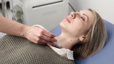 Kadın endokrinolog ultrason ofisinde kadın bir hastaya ultrasonografi yapıyor. Tiroit bezinin ultrason kontrolleri..