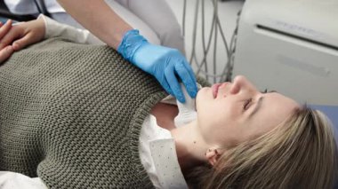 Kadın endokrinolog ultrason ofisinde kadın bir hastaya ultrasonografi yapıyor. Tiroit bezinin ultrason kontrolleri..