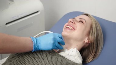 Kadın endokrinolog ultrason ofisinde kadın bir hastaya ultrasonografi yapıyor. Tiroit bezinin ultrason kontrolleri..