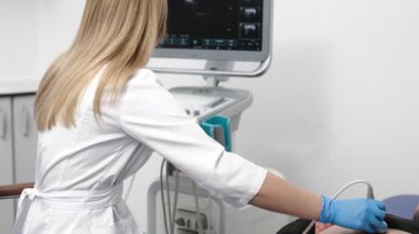 Klinikteki bir adam için karın organlarının ultrason teşhisi. Doktor hastanın karnındaki ultrason sondasını hareket ettiriyor. Doğru tanı koymak için gelişmiş tıbbi teknoloji kavramı.