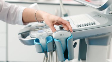 Modern bir tanı merkezinde ultrason cihazını sondayla yakın çekim yap. Profesyonel tıpta hassasiyet ve ileri teknoloji kavramı.