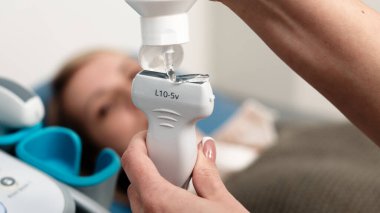 Bir tıp uzmanı ultrason yapar, sonda ve ekipmanlara odaklanır. Tanısal tıptaki modern teknoloji ve profesyonellik kavramı.