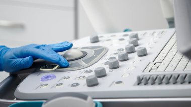 Modern bir tanı merkezinde ultrason cihazını sondayla yakın çekim yap. Profesyonel tıpta hassasiyet ve ileri teknoloji kavramı.