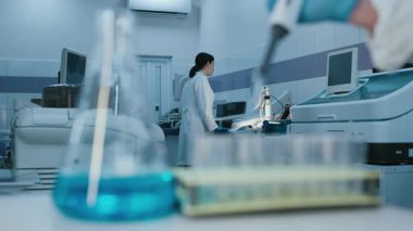 Modern laboratuara sıvı ve pipetle gelişmiş ekipmanlarla birlikte test tüplerini yakın çekim yapın. Yüksek teknolojili bir laboratuarda araştırma ve deneyler kavramı..