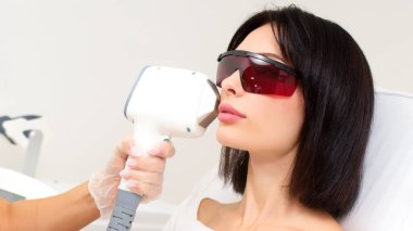 Kadın klinikte lazer tedavisi görüyor.