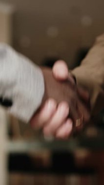 Dikey video. Başarılı bir anlaşmadan sonra iş adamlarının el sıkışması. Güven, başarı ve güçlü iş ilişkileri kavramı