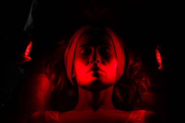 Siyah arka planda kırmızı ışığı olan kadın yüzü