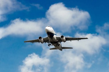 Bulutlu mavi gökyüzünde uçan uçak