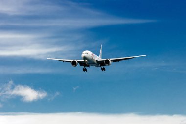 Bulutlu mavi gökyüzünde uçan uçak