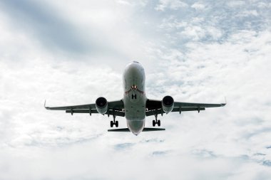 Bulutlu mavi gökyüzünde uçan uçak