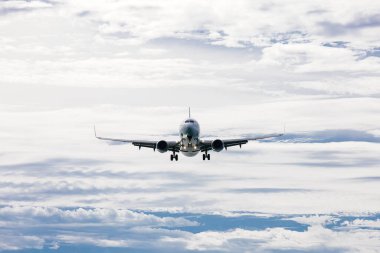 Bulutlu mavi gökyüzünde uçan uçak