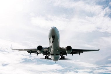 Bulutlu mavi gökyüzünde uçan uçak