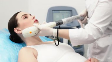Bir kadın güzellik salonunda yüz lazeri temizleme tedavisinden hoşlanır. Rahatlatıcı bir spa ortamında gelişmiş teknoloji ve profesyonel cilt bakımı kavramı.