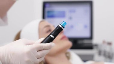 Bir profesyonel, modern bir kuaförde genç bir kadının cildini temizleyip canlandırmak için hidrojen soyarak yüz bakımı yapar. Cilt geliştirme için yenilikçi teknolojiler kullanma kavramı.