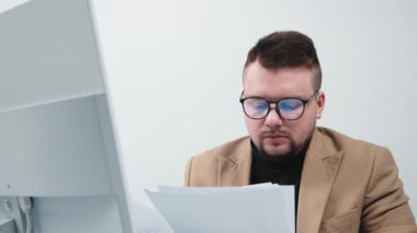 Bir iş adamı, finans müdürü ya da adam toplayıcı, modern bir ofiste bilgisayar başında çalışıyor. Konsept, rahat bir çalışma ortamında bir profesyonelin odaklanma ve üretkenliğini göstermektir..