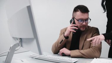 Bir işadamı, çağrı merkezi müdürü veya girişimci, bir bilgisayarın parlak bir ofisinde müşteriye danışır. Konsept uzaktan çalışma, etkili danışmanlık ve müşteri desteği..