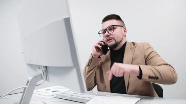 Bir işadamı, çağrı merkezi müdürü veya girişimci, bir bilgisayarın parlak bir ofisinde müşteriye danışır. Konsept uzaktan çalışma, etkili danışmanlık ve müşteri desteği..