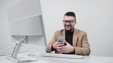 Gözlüklü genç bir girişimci modern bir ofiste nakit sayar. Konsept bir anlık finansal başarı, kazanç ve iş amaçlarına ulaşmak..