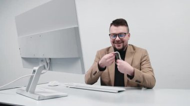 Gözlüklü genç bir girişimci modern bir ofiste nakit sayar. Konsept bir anlık finansal başarı, kazanç ve iş amaçlarına ulaşmak..
