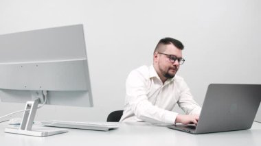Modern bir ofis masasında çalışan düşünceli bir iş adamının portresi. Girişimi için ilham ararken önemli sorunları çözen özgüvenli ve odaklanmış bir adam kavramı.