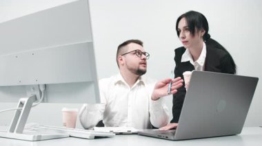 İki çok yönlü iş analisti bir dizüstü bilgisayar kullanarak veri yönetimini tartışıyor. Konsept danışmanlık, eğitim ve istemci desteği bir ofis toplantısı sırasında çevrimiçi teknolojiler yoluyla.