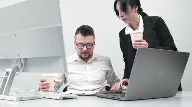 İki çok yönlü iş analisti bir dizüstü bilgisayar kullanarak veri yönetimini tartışıyor. Konsept danışmanlık, eğitim ve istemci desteği bir ofis toplantısı sırasında çevrimiçi teknolojiler yoluyla.