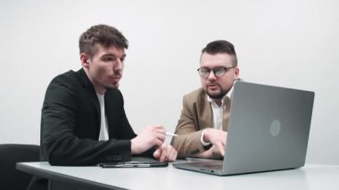 İki çok yönlü iş analisti bir dizüstü bilgisayar kullanarak veri yönetimini tartışıyor. Konsept danışmanlık, eğitim ve istemci desteği bir ofis toplantısı sırasında çevrimiçi teknolojiler yoluyla.