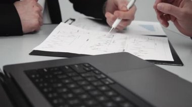 Çalışan ve veri girişi yapan iki çalışanın takım çalışması bir dizüstü bilgisayarda, harita analizlerini inceler ve doğrularlar. Karar verme mekanizması için etkili bir işbirliği ve veri analizi kavramı.